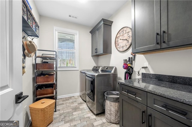 clothes washing area featuring visible vents, baseboards, independent washer and dryer, cabinet space, and brick patterned floor