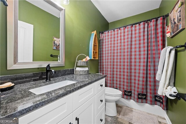 full bath featuring vanity, shower / bathtub combination with curtain, and toilet