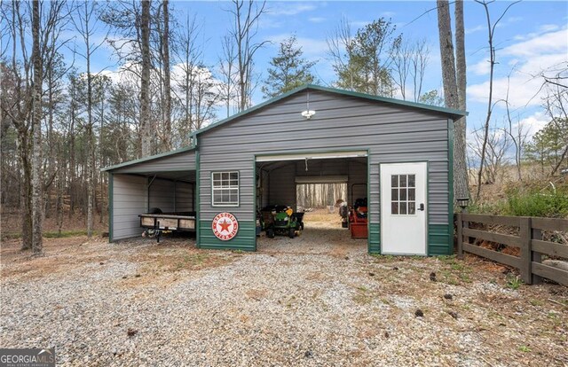 garage featuring fence and a detached garage