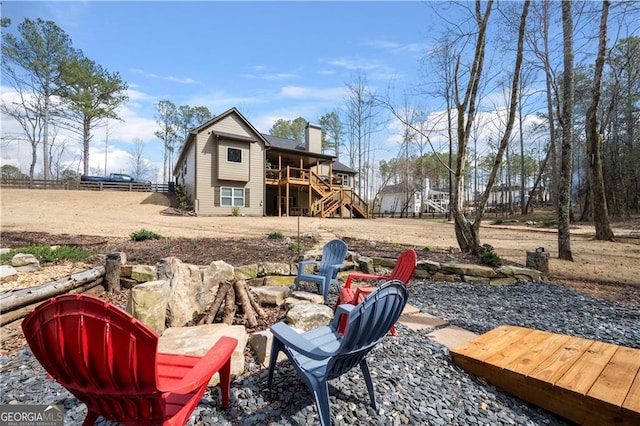 view of yard featuring a fire pit, stairway, fence, and a deck