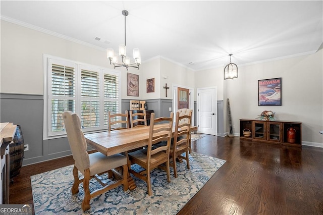 dining room featuring wood finished floors, visible vents, ornamental molding, baseboards, and a chandelier