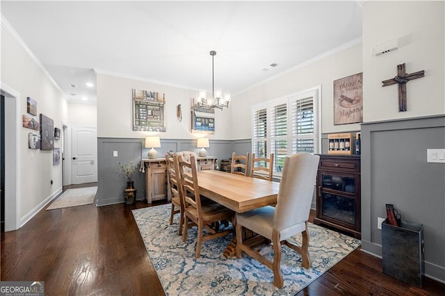 dining space with dark wood finished floors, crown molding, and a chandelier