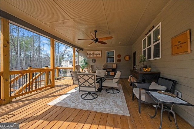 sunroom with ceiling fan and outdoor dining area