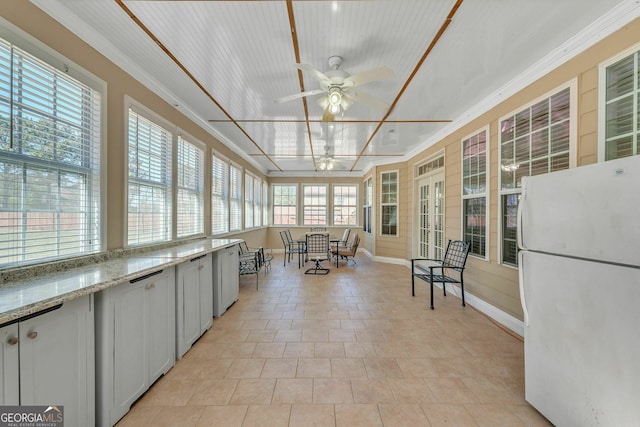 unfurnished sunroom with ceiling fan, outdoor dining space, and french doors