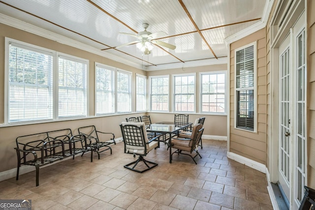 sunroom / solarium featuring baseboards and crown molding