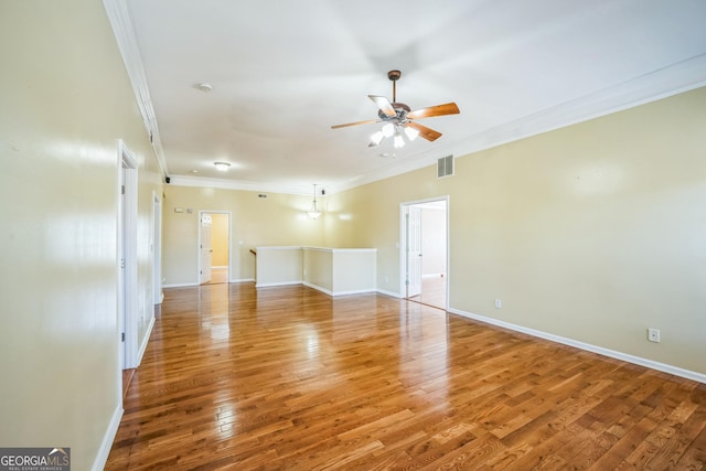 unfurnished living room with a ceiling fan, ornamental molding, baseboards, and light wood-style floors