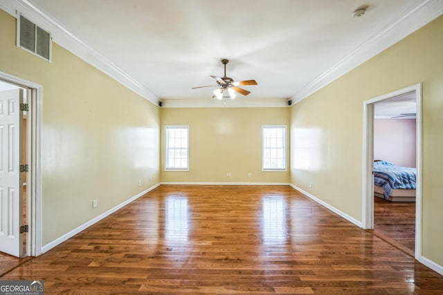 unfurnished room featuring crown molding, visible vents, a ceiling fan, and wood finished floors