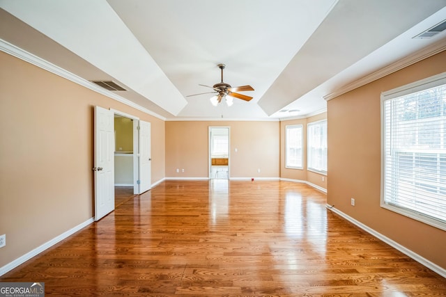 unfurnished room with ornamental molding, baseboards, light wood-style floors, visible vents, and a ceiling fan