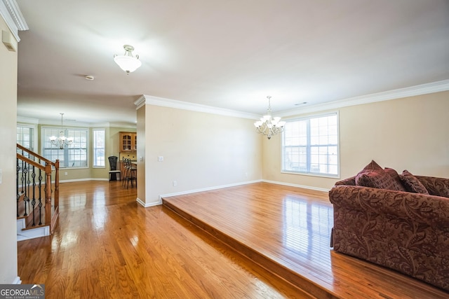 interior space featuring stairs, crown molding, a chandelier, wood finished floors, and baseboards