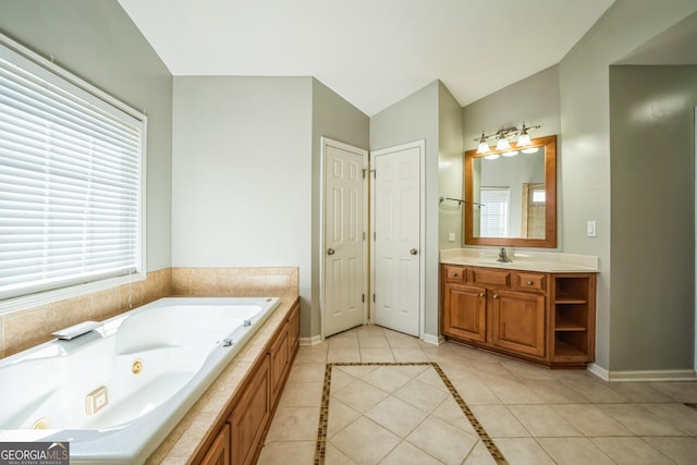 bathroom with tile patterned floors, vaulted ceiling, a whirlpool tub, and baseboards