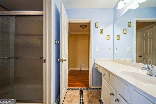 full bath with a stall shower, tile patterned floors, baseboards, and vanity