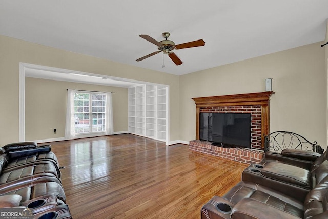 7037 Waters Edge Dr, Stone Mountain, GA 30087 - living area featuring a fireplace, wood finished floors, a ceiling fan, and baseboards