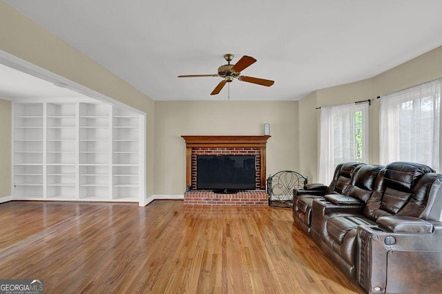 7037 Waters Edge Dr, Stone Mountain, GA 30087 - living room with a ceiling fan, wood finished floors, built in shelves, a fireplace, and baseboards