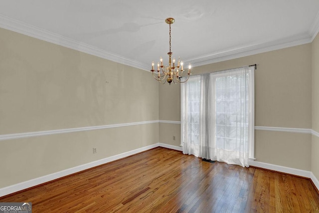 7037 Waters Edge Dr, Stone Mountain, GA 30087 - empty room featuring ornamental molding, baseboards, a notable chandelier, and wood finished floors