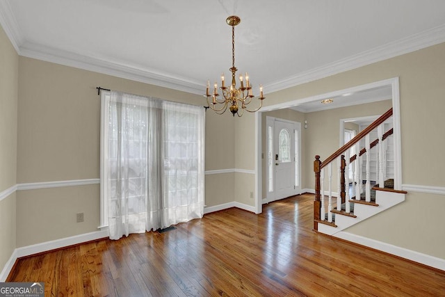 7037 Waters Edge Dr, Stone Mountain, GA 30087 - unfurnished dining area featuring wood finished floors, ornamental molding, baseboards, and a notable chandelier