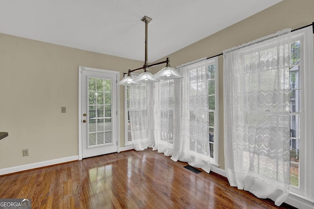 7037 Waters Edge Dr, Stone Mountain, GA 30087 - unfurnished dining area featuring plenty of natural light, wood finished floors, visible vents, and baseboards