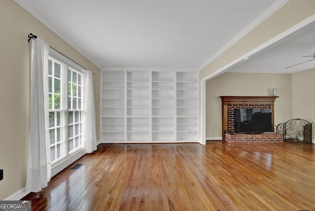 7037 Waters Edge Dr, Stone Mountain, GA 30087 - unfurnished living room with a ceiling fan, hardwood / wood-style flooring, built in features, a brick fireplace, and visible vents