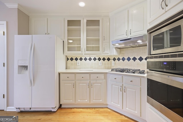 kitchen with stainless steel appliances, under cabinet range hood, white cabinetry, and light countertops