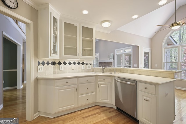 kitchen with a ceiling fan, dishwasher, light countertops, a sink, and light wood finished floors