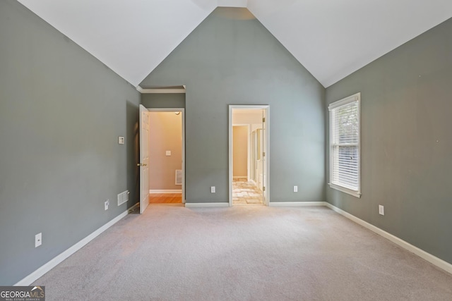 unfurnished bedroom with high vaulted ceiling, carpet, visible vents, and baseboards