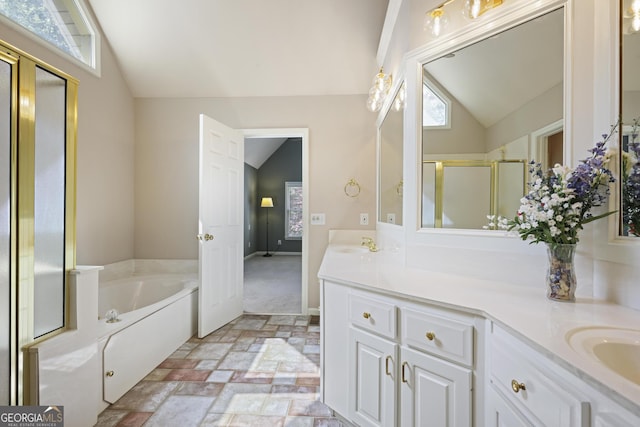 bathroom with a garden tub, a sink, lofted ceiling, a stall shower, and double vanity