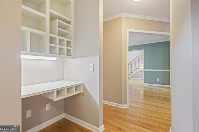 mudroom with baseboards, ornamental molding, and wood finished floors