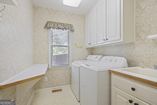 laundry room with wallpapered walls, light tile patterned flooring, visible vents, independent washer and dryer, and cabinet space