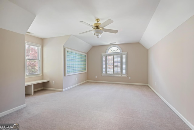 additional living space featuring baseboards, vaulted ceiling, carpet floors, visible vents, and ceiling fan