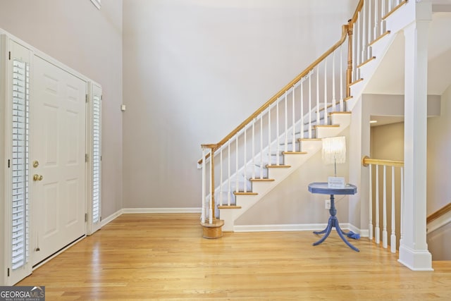 foyer featuring wood finished floors, a towering ceiling, and stairway