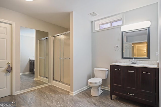 bathroom with a shower stall, vanity, baseboards, and toilet