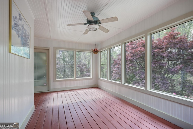 unfurnished sunroom with baseboards and hardwood / wood-style floors