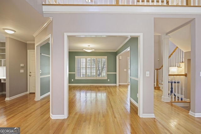 interior space featuring baseboards, stairway, light wood-type flooring, and ornamental molding