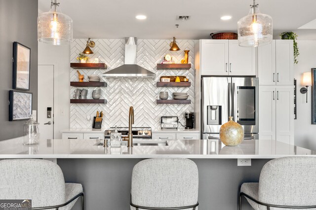 kitchen with wall chimney exhaust hood, stainless steel fridge, open shelves, and decorative backsplash