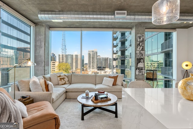 living room featuring a view of city, a healthy amount of sunlight, and floor to ceiling windows