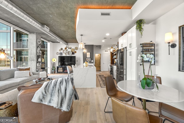living area featuring visible vents, recessed lighting, and light wood-style floors