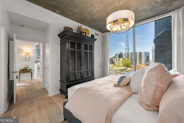 bedroom with a view of city, hardwood / wood-style flooring, baseboards, and multiple windows