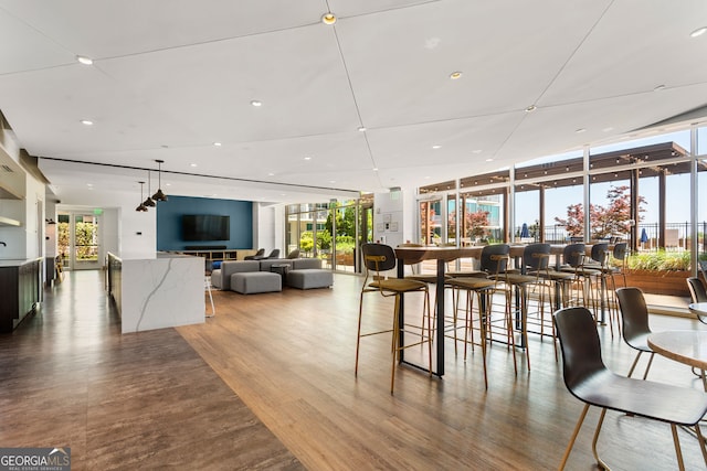 dining space featuring floor to ceiling windows, wood finished floors, and recessed lighting