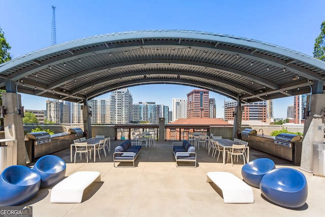view of patio / terrace with a view of city, area for grilling, outdoor dining space, and exterior kitchen