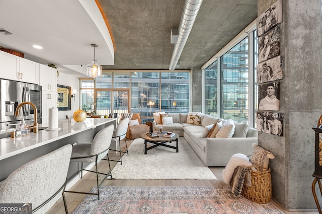 living room featuring visible vents, wood finished floors, and a wall of windows