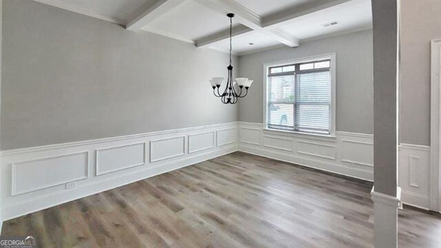 unfurnished dining area featuring visible vents, wainscoting, beamed ceiling, a notable chandelier, and coffered ceiling