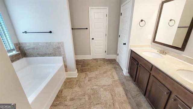 bathroom with a sink, baseboards, a garden tub, and double vanity