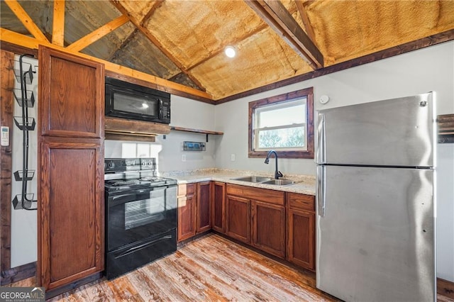 1759 Moccasin Gap Rd, Lula, GA 30554 - kitchen featuring black appliances, a sink, vaulted ceiling, light wood-type flooring, and brown cabinets