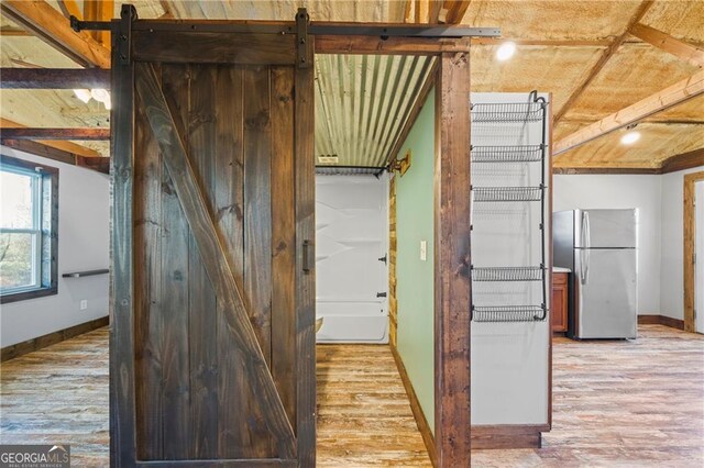 1759 Moccasin Gap Rd, Lula, GA 30554 - kitchen with freestanding refrigerator, baseboards, light wood-type flooring, and a barn door