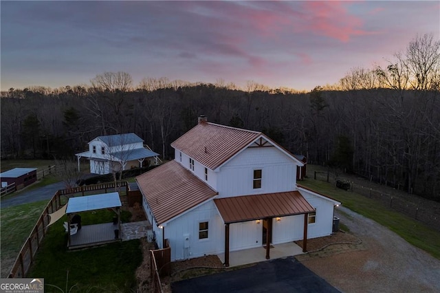 1759 Moccasin Gap Rd, Lula, GA 30554 - view of front of property featuring a standing seam roof, a view of trees, metal roof, a chimney, and driveway
