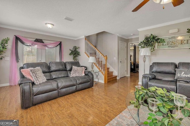 104 Sugar Maple Way, Kingsland, GA 31548 - living room featuring light wood-style floors, stairs, ceiling fan, ornamental molding, and a textured ceiling