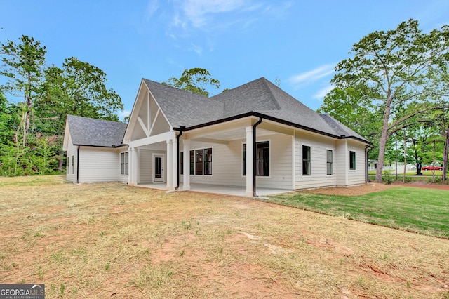 898 Bowdon Junction Rd, Carrollton, GA 30117 - rear view of house featuring a shingled roof, a lawn, and a patio