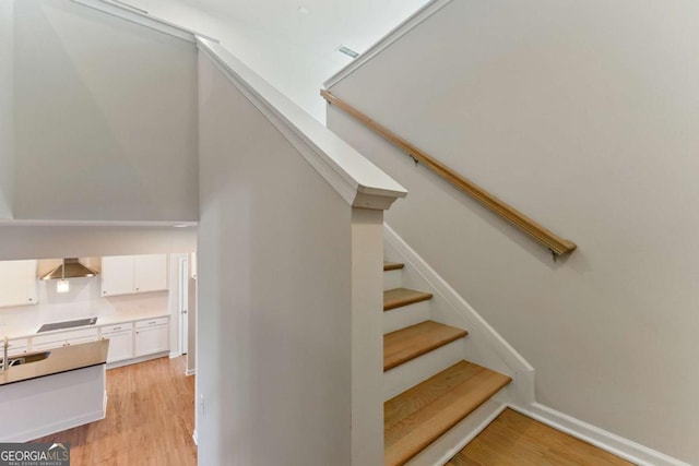 stairway featuring baseboards and wood finished floors