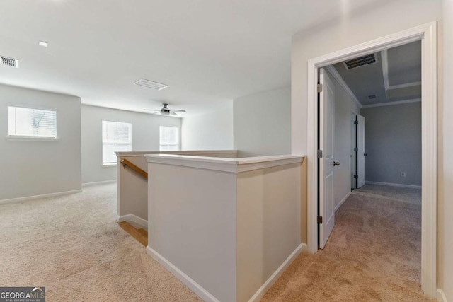 hallway featuring baseboards, an upstairs landing, visible vents, and light colored carpet