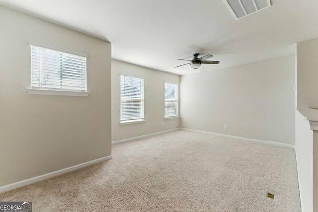 spare room featuring baseboards, visible vents, ceiling fan, and carpet flooring