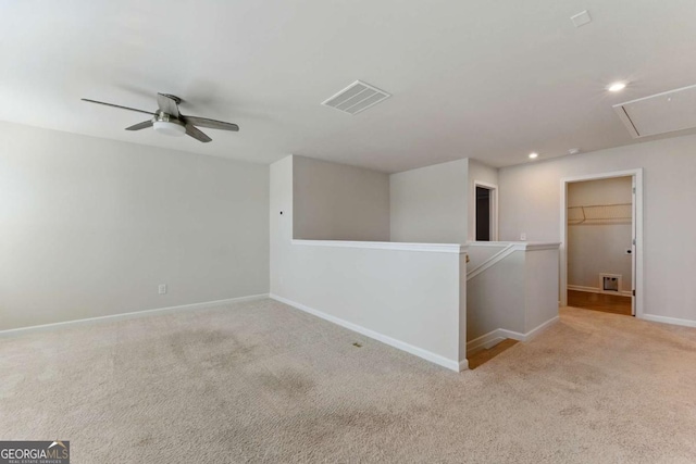 carpeted spare room featuring a ceiling fan, attic access, baseboards, visible vents, and recessed lighting